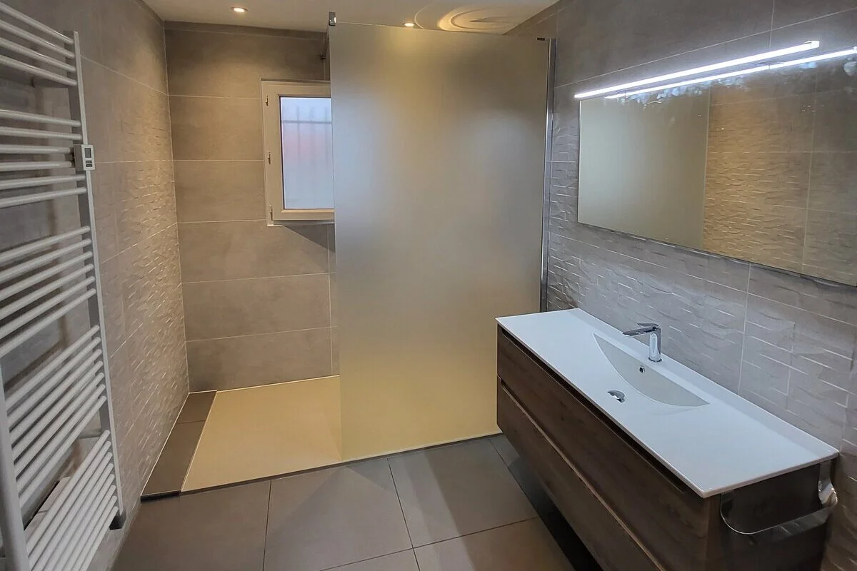 salle de bain avec lavabo, chauffage et douche venant d'être rénovée